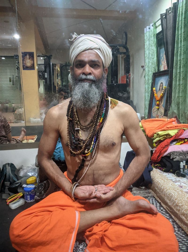 Guru Sanjay Nath wearing rudraksha malas, seated cross-legged
